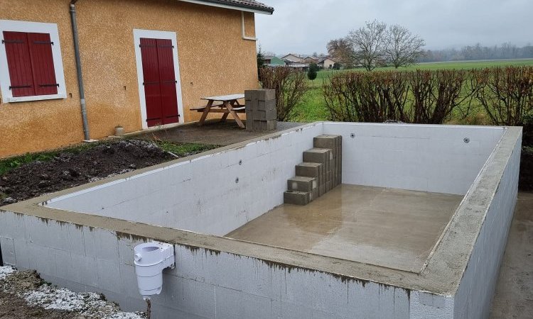 Réalisation d'une piscine sur mesure en bloc polystyrène avec aménagement d'une terrasse bois en mélèze Européen à Clermont. Coulage des murs