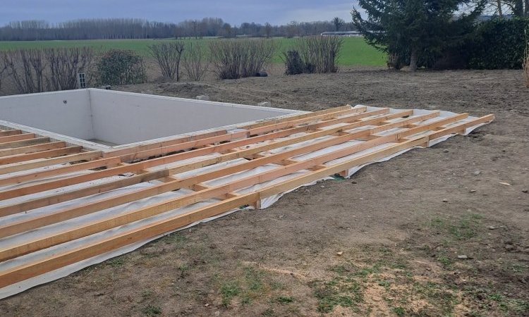 Réalisation d'une piscine sur mesure en bloc polystyrène avec aménagement d'une terrasse bois en mélèze Européen à Clermont. Montage structure de la terrasse