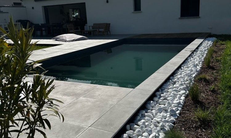 Réalisation d'une piscine sur mesure 7 x 3.5 m avec son mur filtrant avec aménagement des extérieurs en carrelage grès cérame et boix exotique