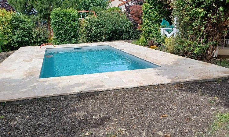 Construction d'une piscine sur mesure 6 x 3 à Clermont avec aménagement des plages en pierre de travertin et réalisation d'une terrasse bois en Mélèze Européen.